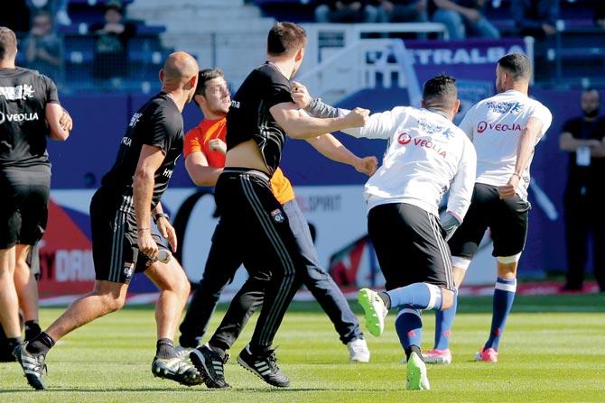 A Bastia supporter fights with a Lyon player during their warm-up session prior to the French league tie in Bastia on Sunday. Pic/AFP