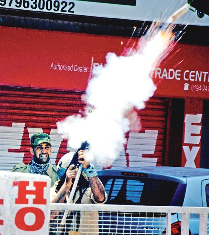 Police fire tear gas shells on stone-pelting students in Srinagar on Monday. Pic/PTI