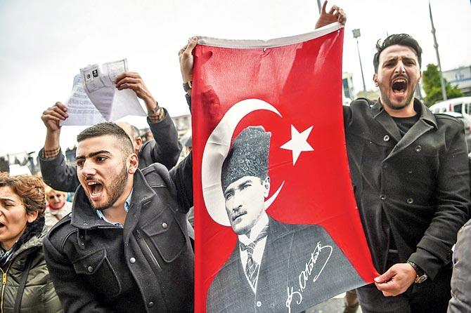 Members of the Republican People’s Party (CHP), hold a flag of Mustafa Kemal Ataturk, founder of modern Turkey as they gather at the Caglayan courthourse to submit their petition 