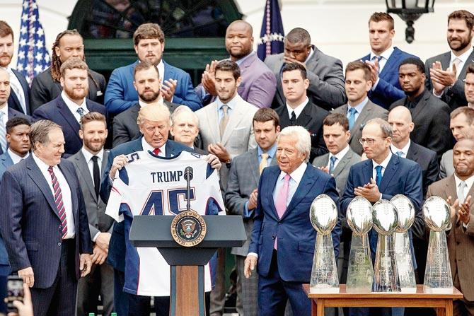 USâu00c2u0080u00c2u0088President Donald Trump is presented with a New England Patriots jersey by head coach Bill Belichick (left) and owner Robert Kraft (center) during a ceremony on the South Lawn of the White House in Washington on Wednesday. Pic/AP,PTI