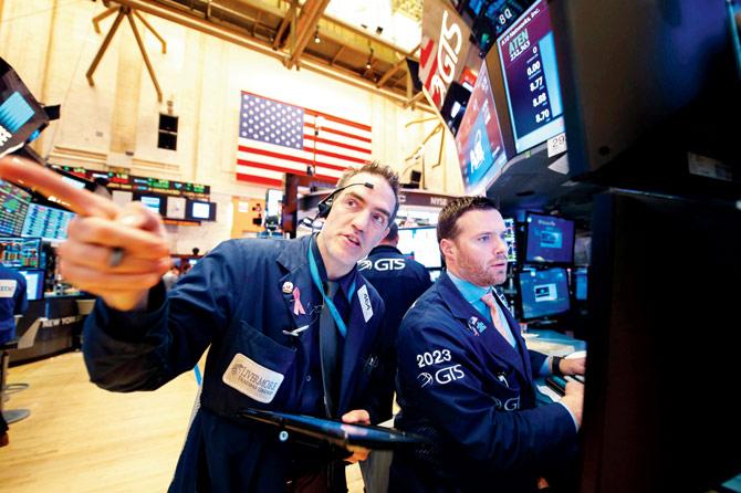 Traders work on the floor at the closing bell of the Dow Industrial Average at the New York Stock Exchange. The Nasdaq surged to a record on Thursday as US stocks shrugged off geopolitical worries and rallied on better earnings and optimism about the American economy. Pic/AFP