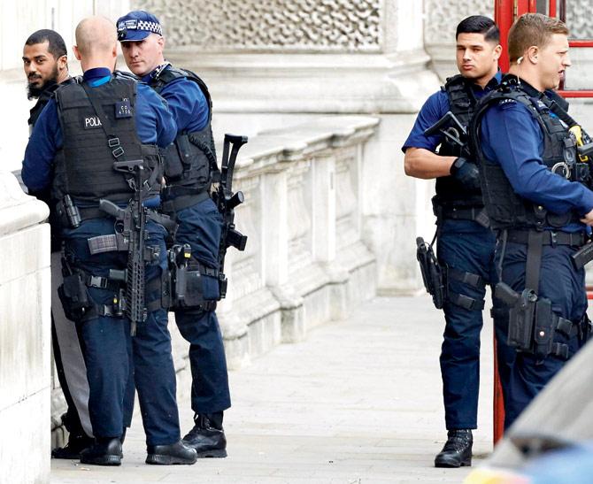 Officers from the British police detain a man in Whitehall on Thursday. Pics/AFP