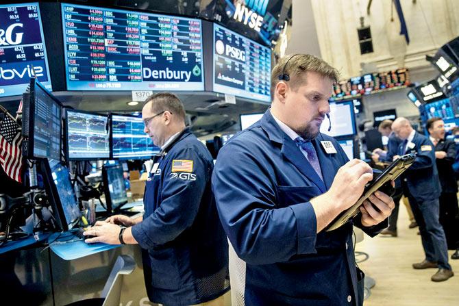 Professionals work on the floor of the New York Stock Exchange (NYSE). The Dow Jones industrial index notched its sixth-straight positive quarter, marking the best run for the Dow since 2006. Pic/GETTY IMAGES