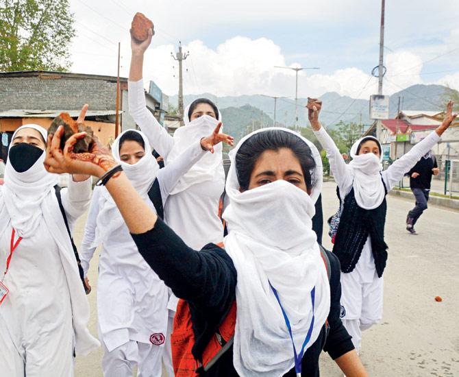 Students armed with stones, taking aim at the security personnel