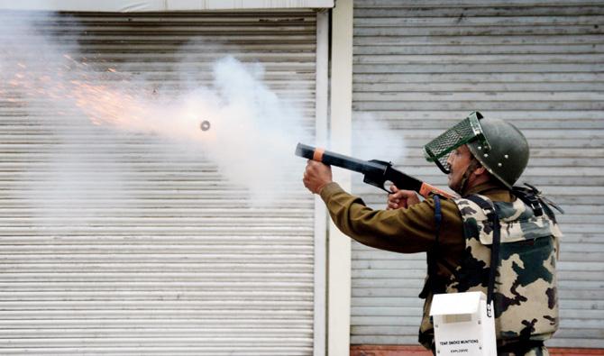 A security personel fires a tear gas shell to disperse stone throwing students. Pics/Umar Ganie