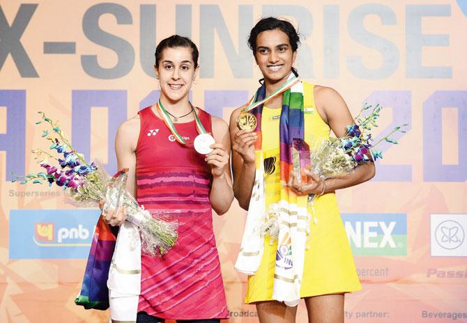 India’s PV Sindhu (right) and Spain’s Carolina Marin pose with their medals after the women’s singles final in New Delhi yesterday. Pics/AFP