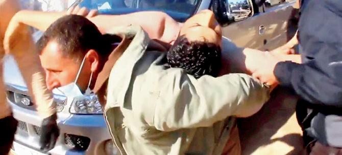 A Syrian man carrying a victim on his back.