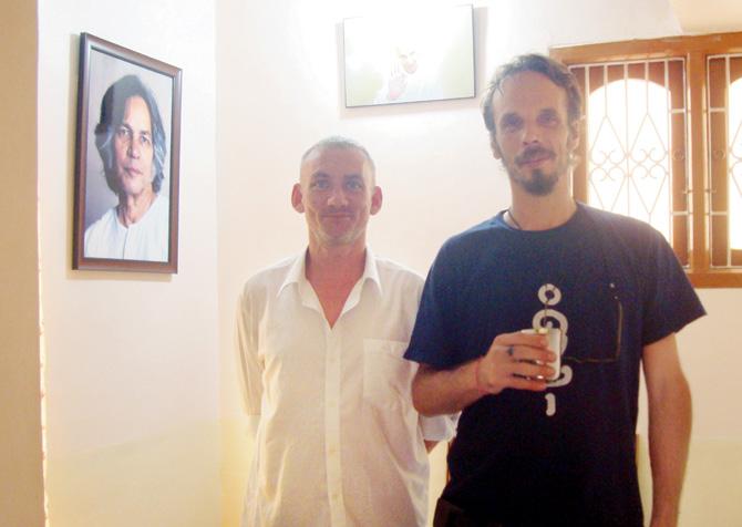 James Farley and Nicolas C Grey with a portait of UG in their office