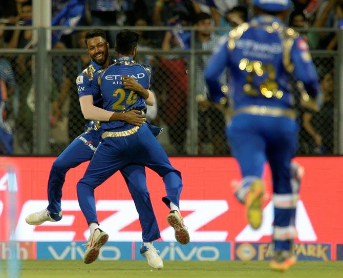 Mumbai Indians cricketer Hardik Pandya (L) celebrates with a teammate Krunal Pandya