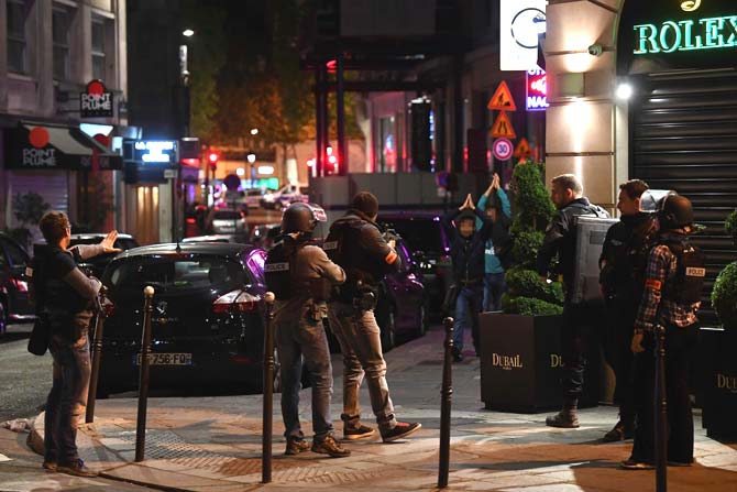 Police officers control passersby near the Champs Elysees in Paris after a shooting. Photos/AFP