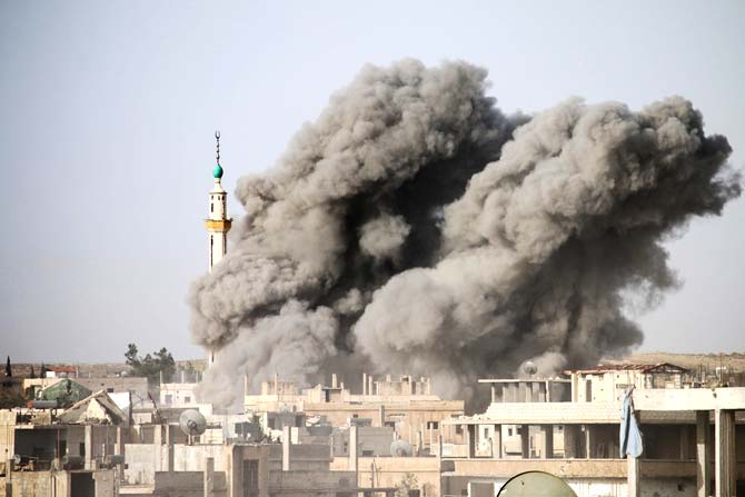 The minaret of a mosque is engulfed by smoke following a reported air strike by Syrian government forces on a rebel-held area in the southern city of Daraa