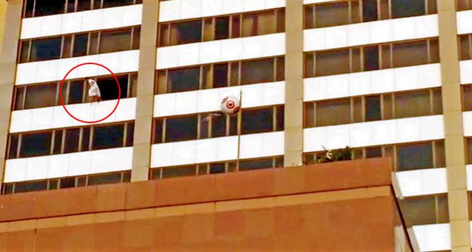 Arjun (circled, in white bathrobe) is seen jumping from his 19th floor room in a screen grab from a video filmed by locals.
