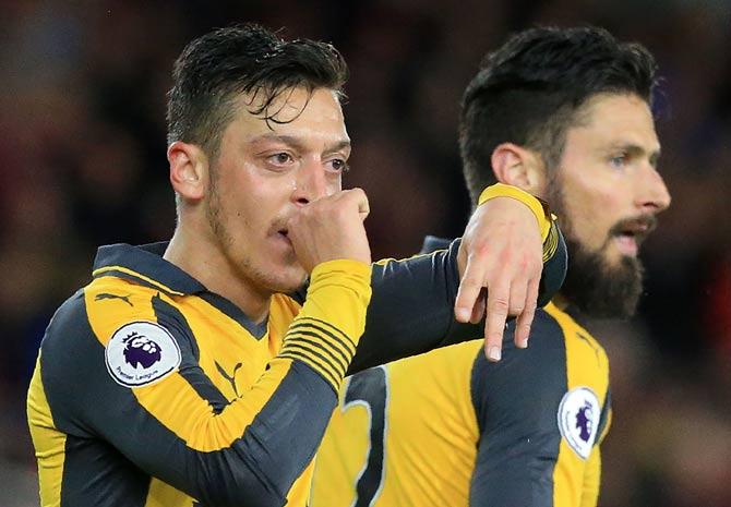 Mesut Ozil (L) gestures as he celebrates scoring his team