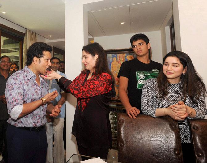 Sachin is fed some cake by wife Anjali Tendulkar, with Arjun and Sara standing beside