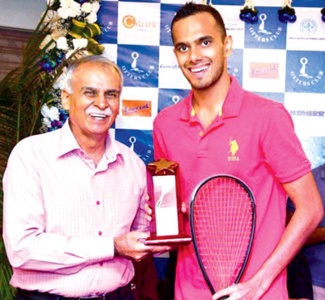 Aditya Jagtap (right) receives the winners trophy from former squash player Raj Manchanda