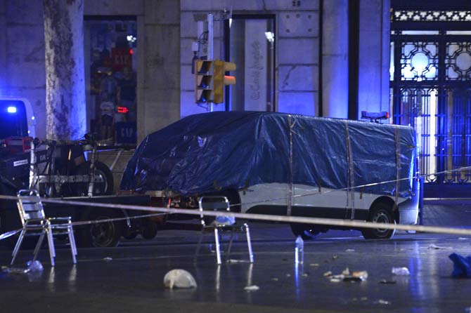 The van who ploughed into the crowd, killing at least 13 people and injuring around 100 others is towed away from the Rambla in Barcelona. Pic/AFP