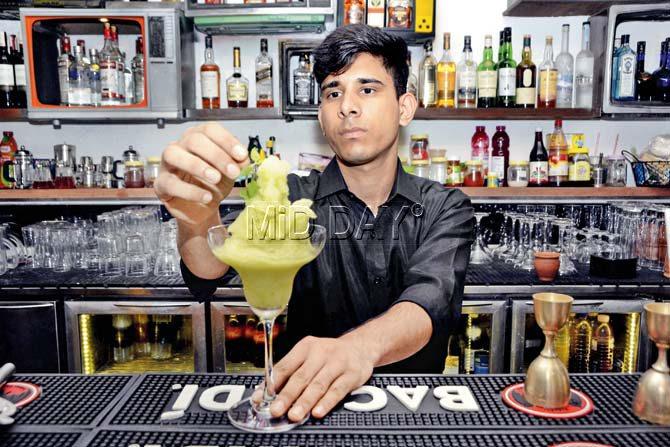 The bartender at +91 garnishes the Slushy Aam Imli Panna. Pic/Sneha Kharabe