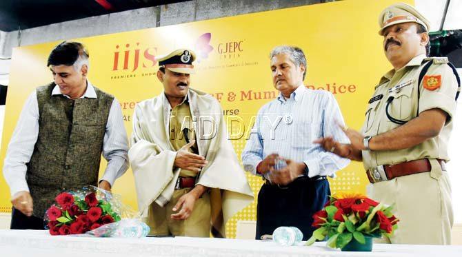A Gems and Jewellery Export Promotion Council official felicitates the two CISF officers, as president of Bharat Diamond Bourse, A Mehta, looks on. Pic/Nimesh Dave