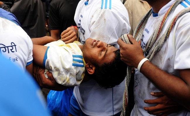An injured boy is being carried by friends after falling during dahi handi in Mumbai. Photo/ AFP