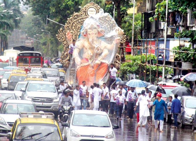 Ganesh idols being taken to pandals in long procession and accompanied by loud music. Pic/Tanvi Phondekar
