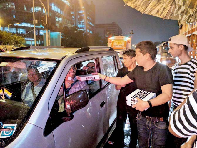 The staff at the Bandra Project hands out free pizzas to motorists stuck in a traffic jam in the suburb