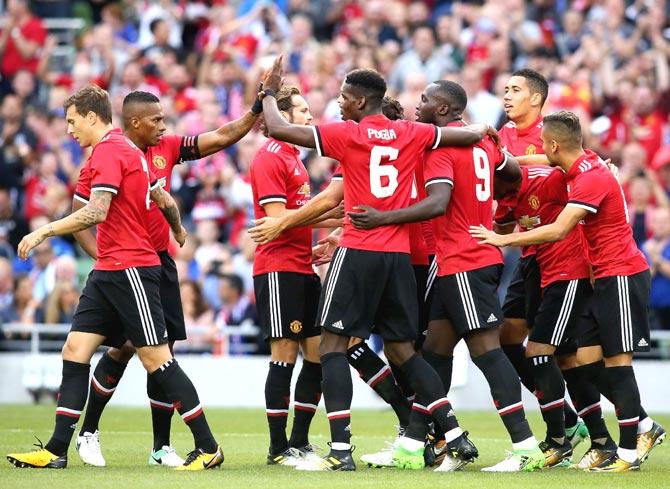 Manchester United players celebrate their first goal scored by Manchester United