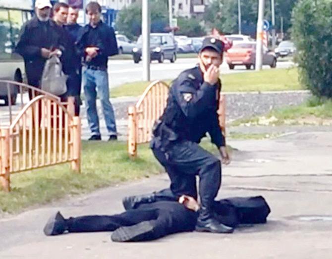 YouTube footage showed a cop kneeling above a a black-clad man in Russia