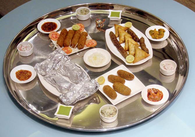 (Clockwise from left) Bheja Hara Masala, Nalli Nihari, Paya Soup, Tandoori Roti, Dal Chawal Palidu, Pizza Naan and Bohri Biryani (centre)