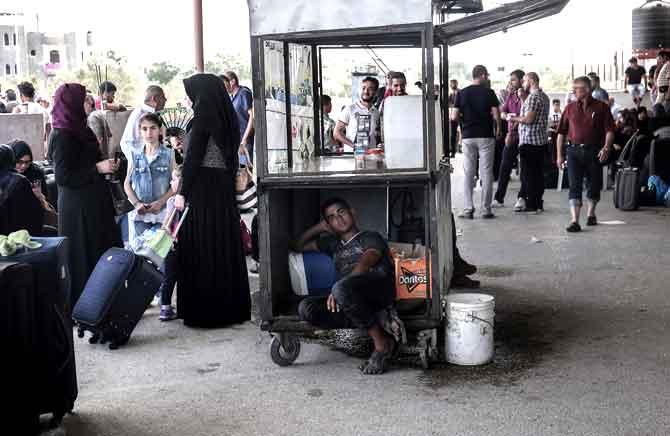 Palestinians wait for travel permits to cross into Egypt through the Rafah border crossing after it was partially opened by Egyptian authorities, in Rafah. Pic/AFP