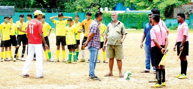 In the absence of MSSA football secretary Sebastian Fernandes, St Stanislaus coach Henry Picardo centre in jeans talks to MSSA groundstaff as Don Bosco coach Abbas Ali Rizvi left, red jersey looks on, ahead of the MSSA Divison I tie at Azad Maidan yesterday. Pics/Suresh Karkera