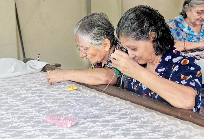  Pervin Vajifdar (left) and Katy Patel work expert fingers over an antique lace saree at the Ratan Tata Institute on Hughes Road. Pic/Tanvi Phondekar