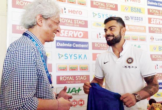 India captain Virat Kohli presents a signed India shirt to cricket writer R Kaushik who will cover his 100th Test today at the Sinhalese Sports Club ground in Colombo