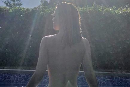 Manchester United footballer's girlfriend exposes bare back in topless photo