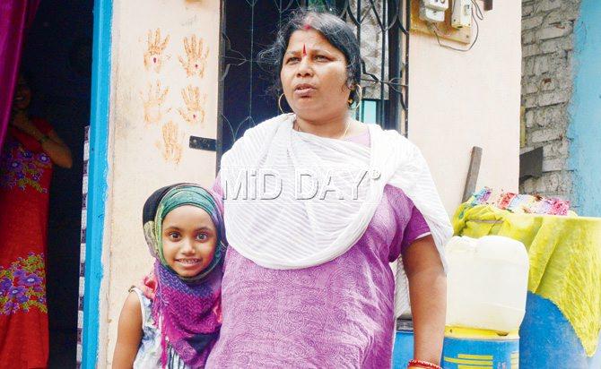 Sonali Majhi, like many children in the area, has been tying her head with a scarf, taking it off only before going for a shower. Exterior walls of several houses in the Samtanagar slum area have been plastered with hand-prints to ward off evil