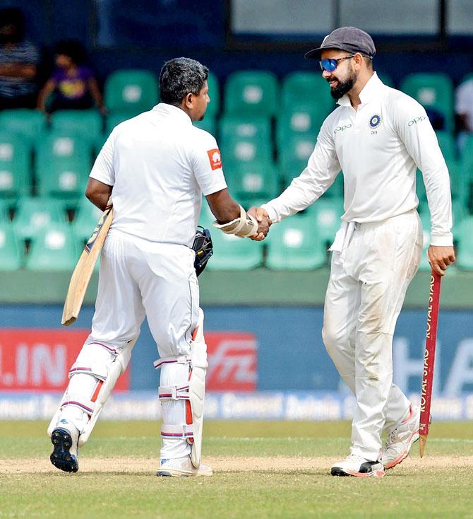 Captain Virat Kohli (right) is congratulated by Sri Lanka’s Rangana Herath after India