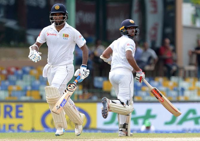 Sri Lankan cricketer Dimuth Karunaratne (L) and teammate Kusal Mendis run between the wickets during the third day of the second Test match between Sri Lanka and India at the Sinhalese Sports Club (SSC) Ground in Colombo. AFP PHOTO