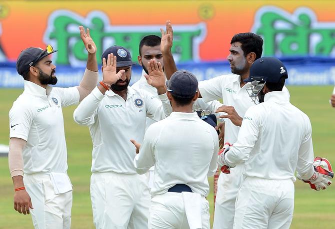 Indian cricketer Ravichandran Ashwin (2R) celebrates with his teammates after he dismissed Sri Lankan cricketer Dimuth Karunaratne during the third day of the third and final Test match between Sri Lanka and India at the Pallekele International Cricket Stadium in Pallekele on August 14, 2017