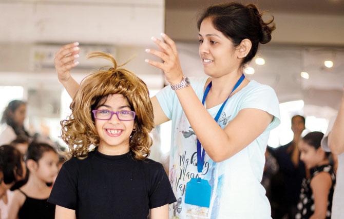 Keira Munim, who plays Goldilocks, tries on a wig at the rehearsal