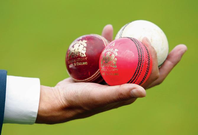A reporter takes a closer look at the three types of cricket balls during a nets  session at Edgbaston on Tuesday in Birmingham. PIC/Getty Images
