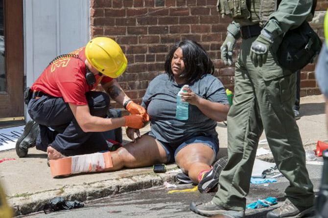 People receive first-aid after a car accident ran into a crowd of protesters in Charlottesville, VA on August 12, 2017. A picturesque Virginia city braced Saturday for a flood of white nationalist demonstrators as well as counter-protesters, declaring a local emergency as law enforcement attempted to quell early violent clashes.