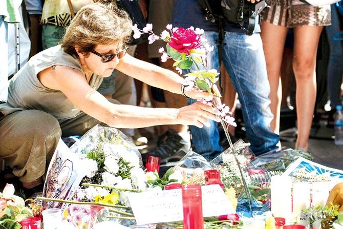 A woman places flowers on Las Ramblas boulevard yesterday where the terror attack took place in Barcelona on Thursday. Pic/Getty Images