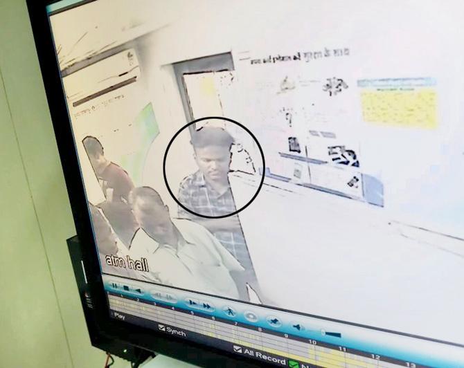 CCTV footage shows the accused (circled) helping the victim to link his Aadhaar card at the ATM. Pic/Hanif Patel