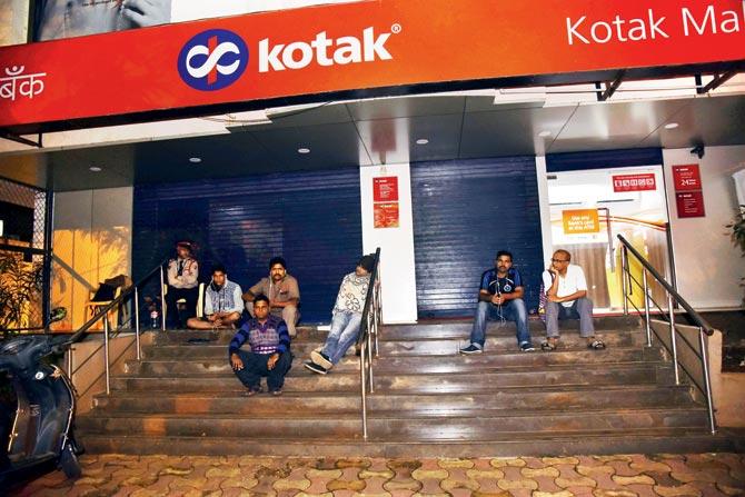 Mumbaikars wait outside the Juhu branch of Kotak Mahindra Bank at dawn to bag one of the first 20 tokens for Aadhaar enrolment. Pic/Pradeep Dhivar