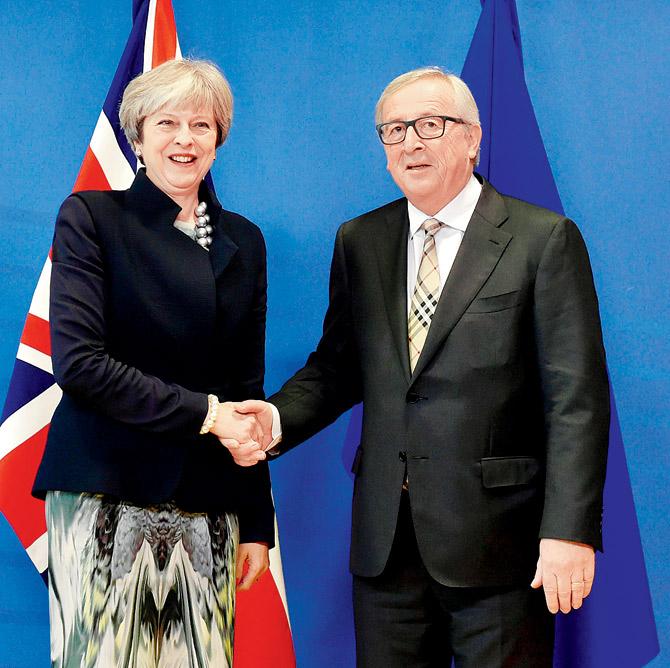 British Prime Minister Theresa May shakes hands with European Commission chief Jean-Claude Juncker. pic/afp