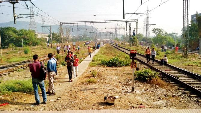 Commuters walk along tracks after Harbour line services collapsed