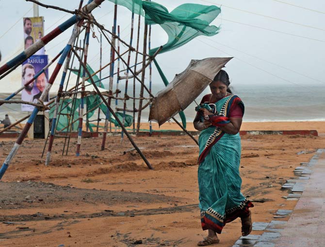 A woman braving the strong winds and rain in Thiruvananthapuram. Pic/AFP