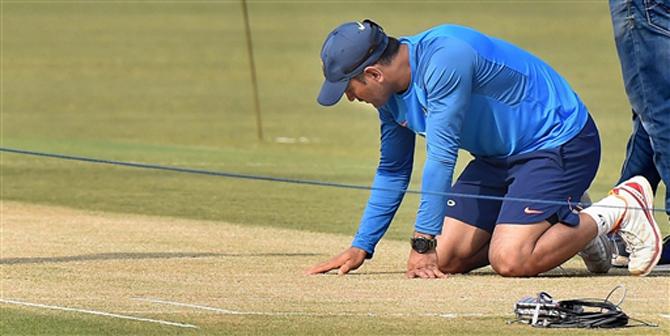 Indias MS Dhoni inspects the pitch during a practice session for the inaugural T20 cricket match, in Cuttack on Tuesday. PTI