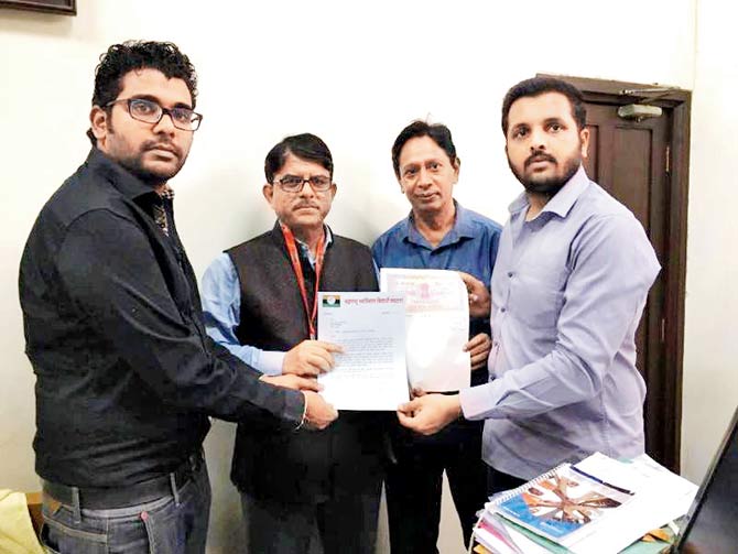 Members of the MSVS give the letter and stamp paper to (centre) Dinesh Kamble, MU registrar