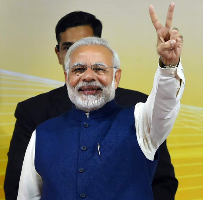 Prime Minister Narendra Modi flashes victory sign at a felicitation function before the party