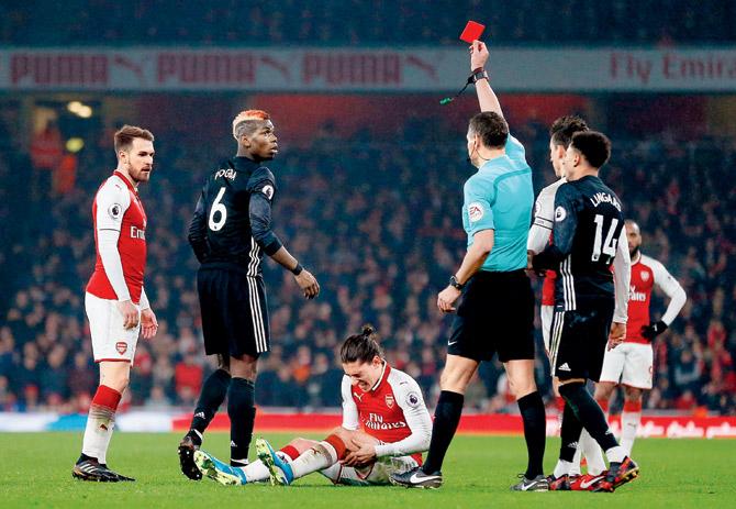 Manchester Uniteds Paul Pogba (second from left) is shown the red card during their EPL match against Arsenal on Saturday. pic/AFP